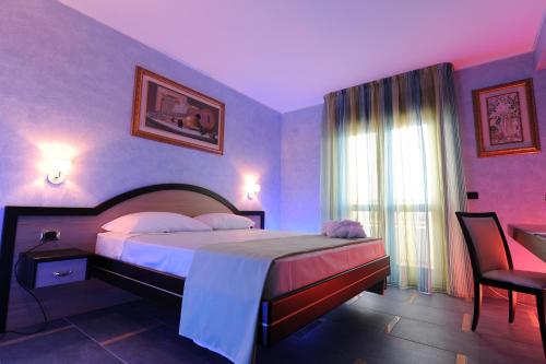 a bedroom with a bed in a purple room at Grand Hotel Paradiso in Catanzaro Lido