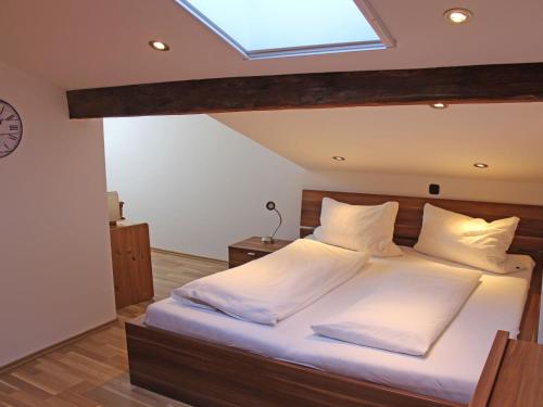 Schlafzimmer mit einem Bett mit weißer Bettwäsche und einem Dachfenster in der Unterkunft Ferienwohnung Kohlstatt in Kiefersfelden