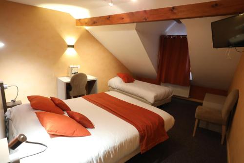 a hotel room with two beds and a television at Logis Le Bourguignon in Bèze