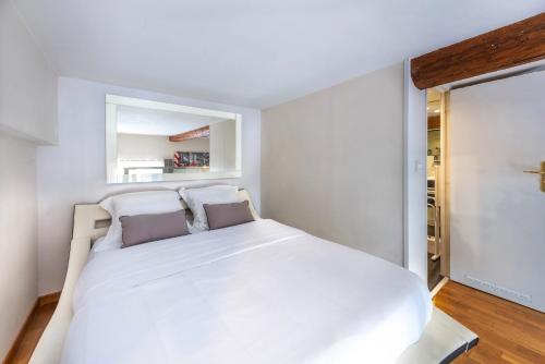 um quarto com uma grande cama branca e uma janela em VIEW on Principal Massena place, beach 2 min walk em Nice