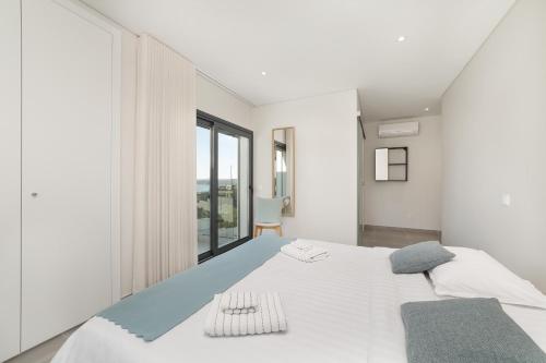 a bedroom with a large white bed and a window at Lagoa Views - Holiday Apartment by SCH in Foz do Arelho
