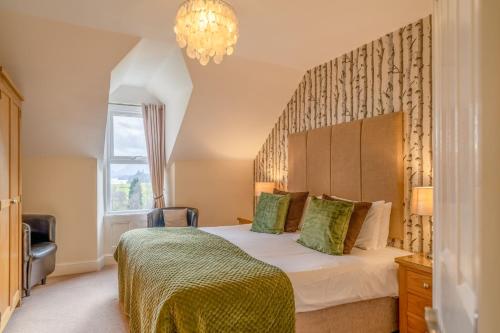 a bedroom with a bed and a chandelier at Highfield in Keswick