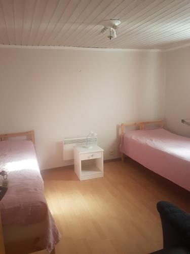 a small room with two beds and a table at Ekonomirum i Karlstad 