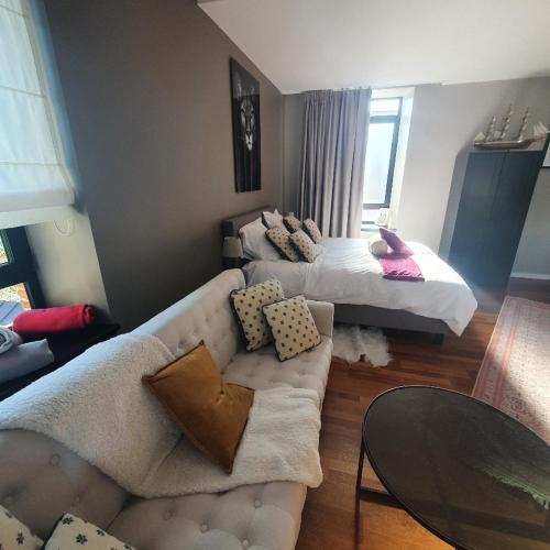 - un salon avec un canapé et un lit dans l'établissement Résidence Montagne du Parc, à Nivelles