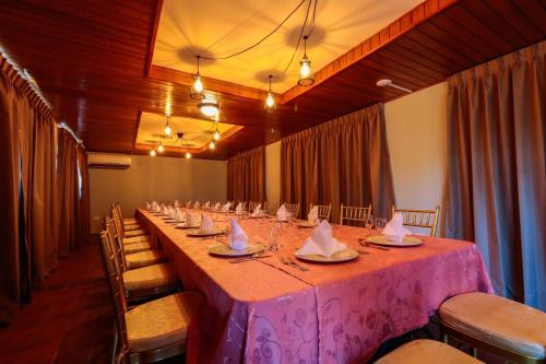 a long table in a room with a pink table cloth at Hotel Faranda Guayacanes in Chitré