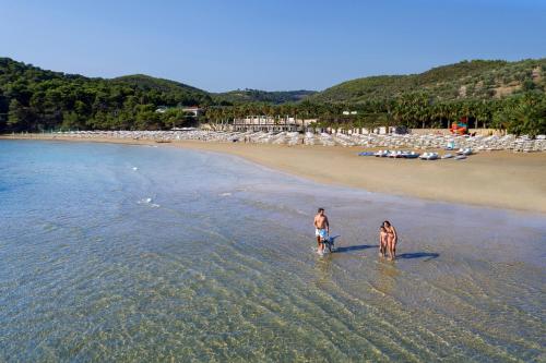 two people walking in the water on the beach at Gattarella Family Resort - Self catering accommodations in the pinewood in Vieste