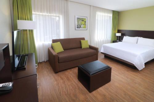 a hotel room with a bed and a couch at Staybridge Suites San Luis Potosi by IHG in San Luis Potosí