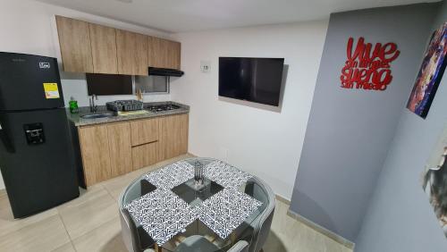 a kitchen with a table and a kitchen with a refrigerator at Hermoso Apartamento Entero - Parqueadero - Pino in Ibagué
