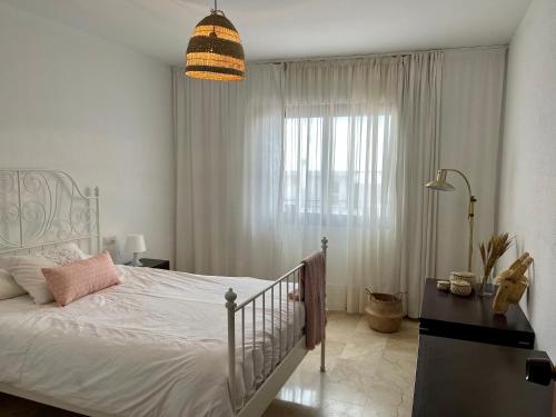 1 dormitorio con cama blanca y ventana grande en Apartamento Alyanna, en Mijas