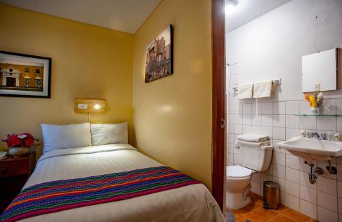 een kleine badkamer met een bed en een wastafel bij Eco Inn in Cuzco