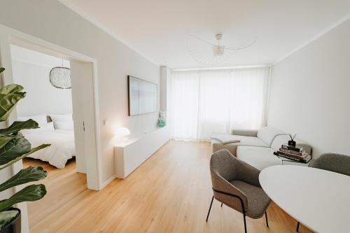 a white living room with a white couch and a table at Moderne ruhige 2-Zimmer Wohnung in Coswig in Coswig