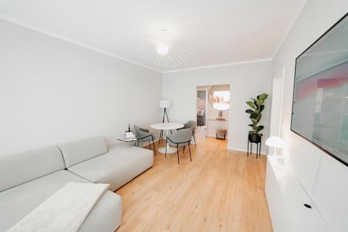 a white living room with a white couch and a table at Moderne ruhige 2-Zimmer Wohnung in Coswig in Coswig