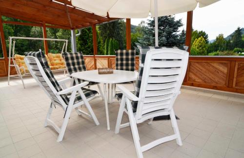 einen weißen Tisch und Stühle auf einer Veranda mit Sonnenschirm in der Unterkunft Ferienwohnung Landzettel in Amorbach