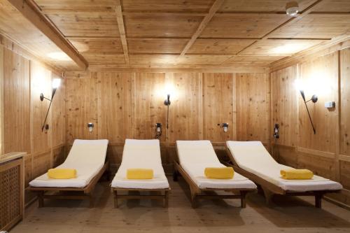 - une salle de spa avec des chaises blanches et des oreillers jaunes dans l'établissement Chalet Barbara, à Arabba