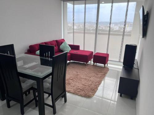 ein Wohnzimmer mit einem roten Sofa und einem Tisch in der Unterkunft SILVER PARK in Cúcuta