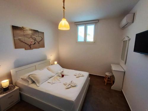 a bedroom with a bed with white sheets and flowers on it at Sweet Home Nikorenia 1 in Krotiri