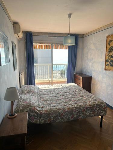 une chambre avec un lit et une grande fenêtre dans l'établissement Appartamento con vista Promenade, à Nice