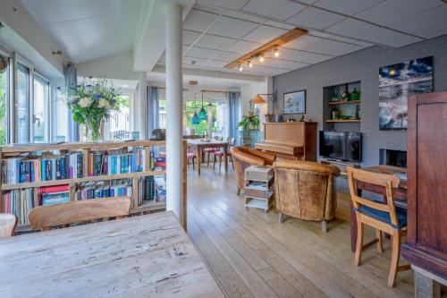 a living room with a piano and a dining room at B&B Boutique Hotel De Waal in De Waal