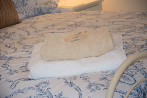 a pile of towels sitting on top of a bed at Higher Weddicott Barn Holiday Cottage - Self Catering in Chagford