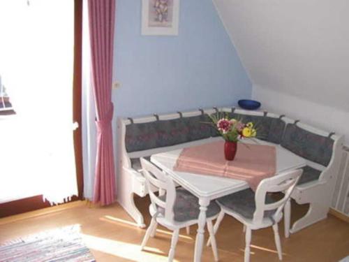 einen weißen Tisch und Stühle in einem Zimmer in der Unterkunft Ferienwohnung Lioba Kunst in Amorbach
