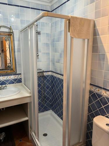 a small bathroom with a shower and a sink at Casa Kini in Cazalla de la Sierra