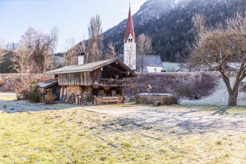 an old building with a church with a steeple at Stoffelhäusl in Reith im Alpbachtal