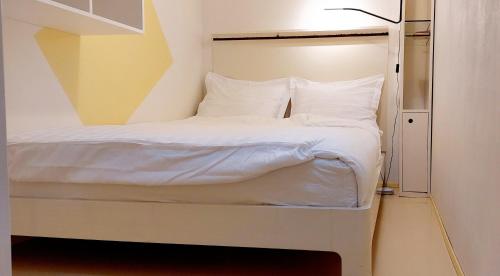 een slaapkamer met een bed met witte lakens en kussens bij Natuurhuisje Heerlijkheid Beek in Berg en Dal