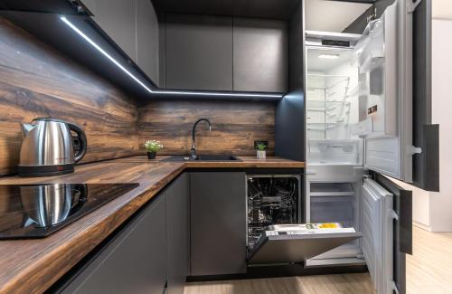 a kitchen with a sink and a refrigerator at Люкс на Бориспільській ЖК Олімпік Парк, генератор на будинку in Kyiv