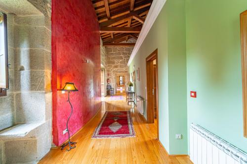 a hallway of a building with a red wall at Casa Rural Pazo San Damian in Amoeiro