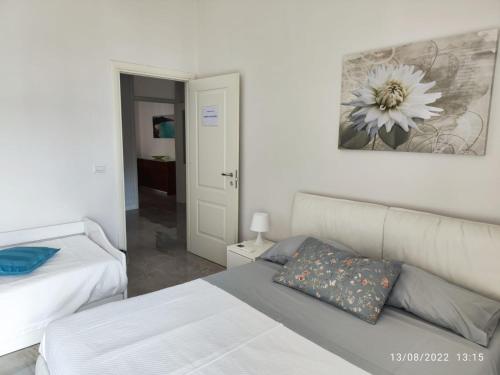 a bedroom with two beds and a flower picture on the wall at Residenza Tafuri in Salerno