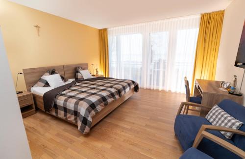 ein Hotelzimmer mit einem Bett und zwei Stühlen in der Unterkunft Hotel Restaurant Sokrates in Güttingen