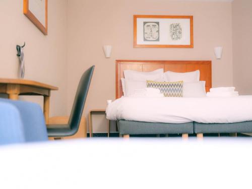 a hotel room with two beds and a table and chairs at Logis Hôtel de l'Europe in Poitiers