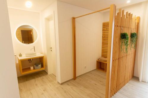a hallway with a bathroom with a sink and a mirror at Ericeira Surf Apartments in Ericeira