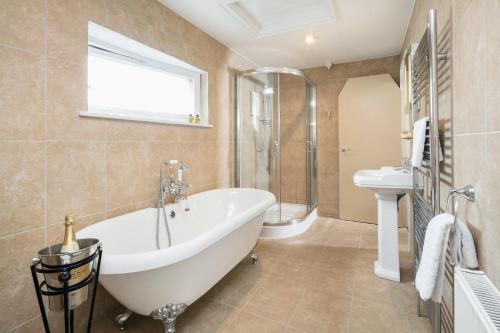 ein Badezimmer mit einer Badewanne, einem WC und einem Waschbecken in der Unterkunft Highfield in Keswick