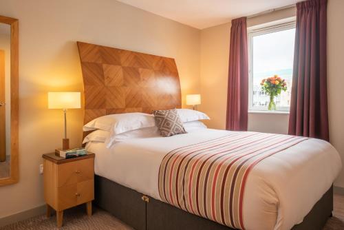 バーミンガムにあるプレミア スイーツ バーミンガムの大きなベッドと窓が備わるホテルルームです。