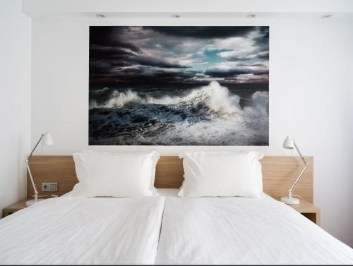 a bedroom with a bed with a painting on the wall at Storm Hotel by Keahotels in Reykjavík