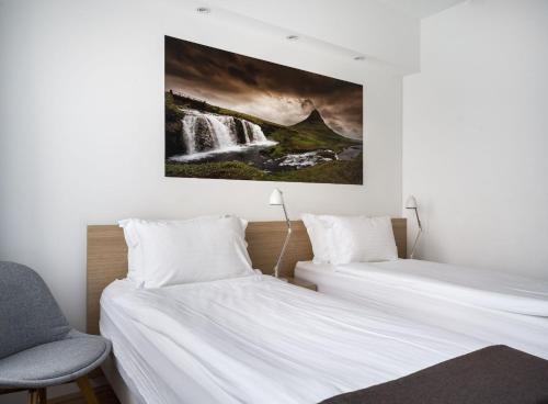 two beds in a room with a waterfall painting on the wall at Storm Hotel by Keahotels in Reykjavík