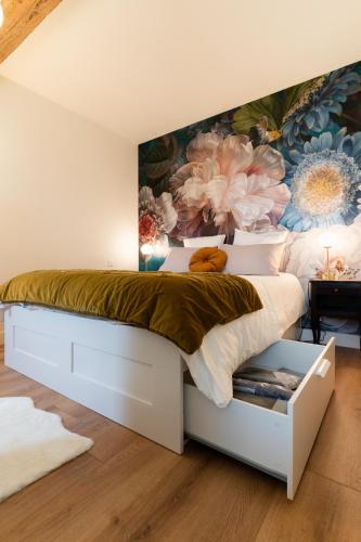 a bedroom with a large bed with a floral wall at Sur la place , centre village cosy & calme 2CH in Lapeyrouse-Fossat