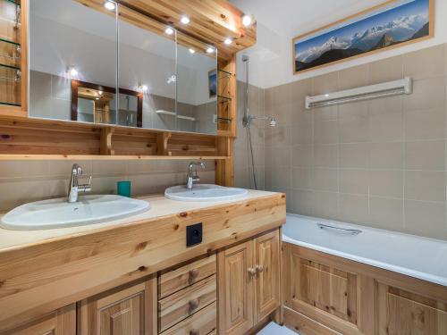 une salle de bain avec deux lavabos et un miroir dans l'établissement Appartement de standing 3 chambres en plein centre de Val d'Isère, proche pistes et remontées mécaniques - FR-1-567-33, à Val dʼIsère