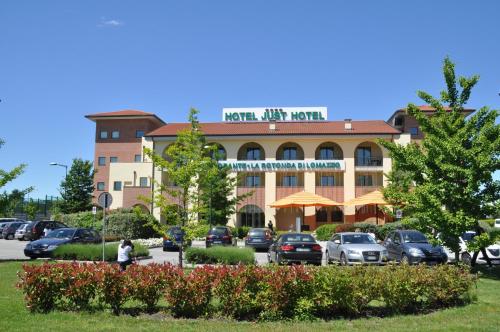 a hotel with cars parked in a parking lot at Just Hotel Lomazzo Fiera in Lomazzo