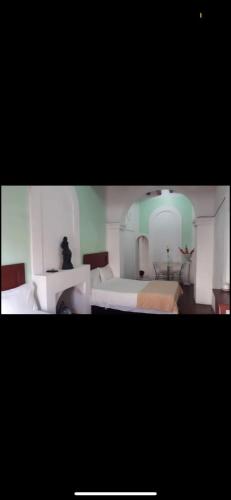 a bedroom with two white beds and a room with at Departamento en Centro de Querétaro in Querétaro