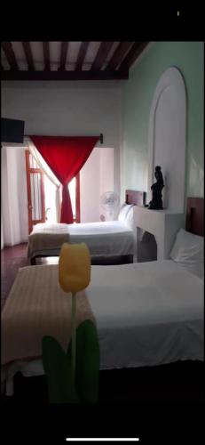 een slaapkamer met 3 bedden en een rood gordijn bij Departamento en Centro de Querétaro in Querétaro