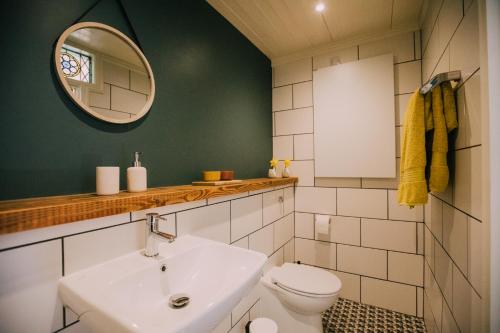 a bathroom with a sink and a toilet and a mirror at The Old Workshop in St Ives