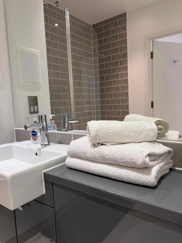 y baño con lavabo blanco y espejo. en Luxury 2 Bed Townhouse in Royal Wharf, en Londres