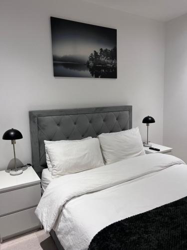 1 dormitorio con 1 cama blanca grande y 2 lámparas en Luxury 2 Bed Townhouse in Royal Wharf, en Londres