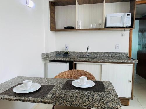 a kitchen with a table with two cups on it at Home service na praia de Cabo Branco in João Pessoa