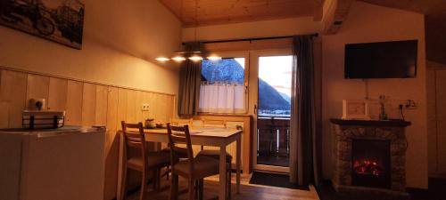 バッハにあるFerienhaus Lechtaler Alpenのキッチン(テーブル、椅子、暖炉付)
