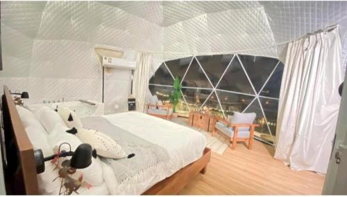 - une chambre avec un lit et une grande fenêtre dans l'établissement Desert star camp, à Wadi Rum