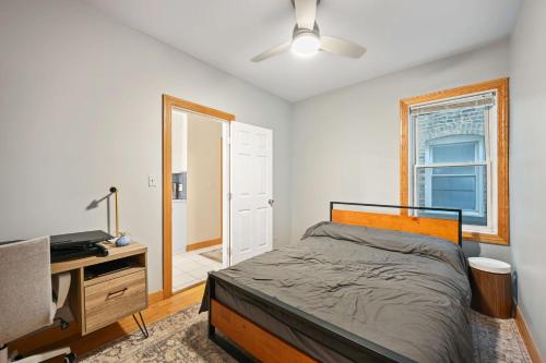 Dormitorio con cama, escritorio y TV en 2 Bed Apt w/ Office, Free Parking, Near Wrigley, en Chicago