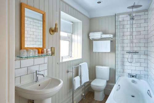 Anglesey Arms Hotel في جسر ميناي: حمام أبيض مع حوض ومرحاض